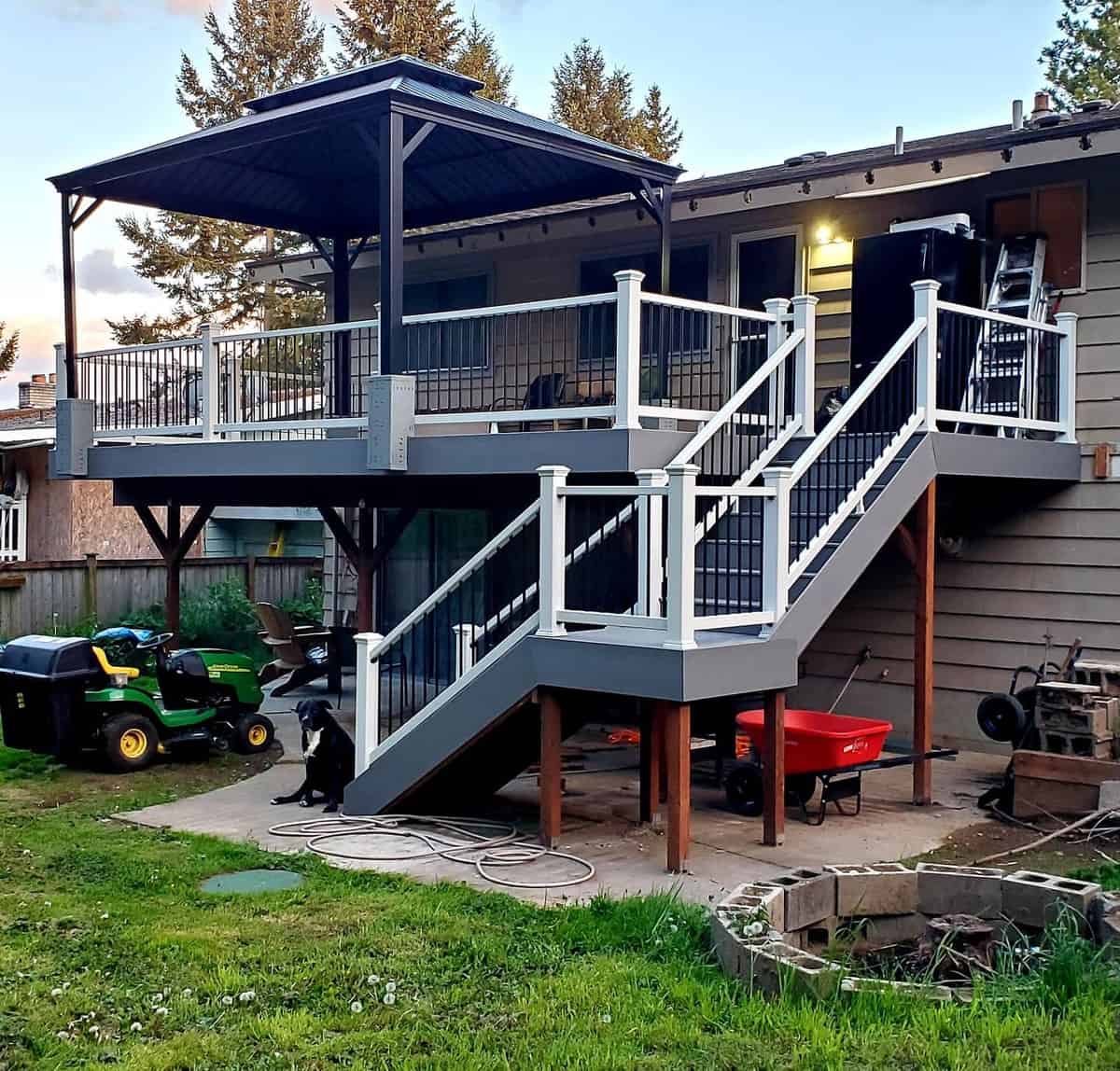 off the ground, gray deck, black gazebo, white railings 