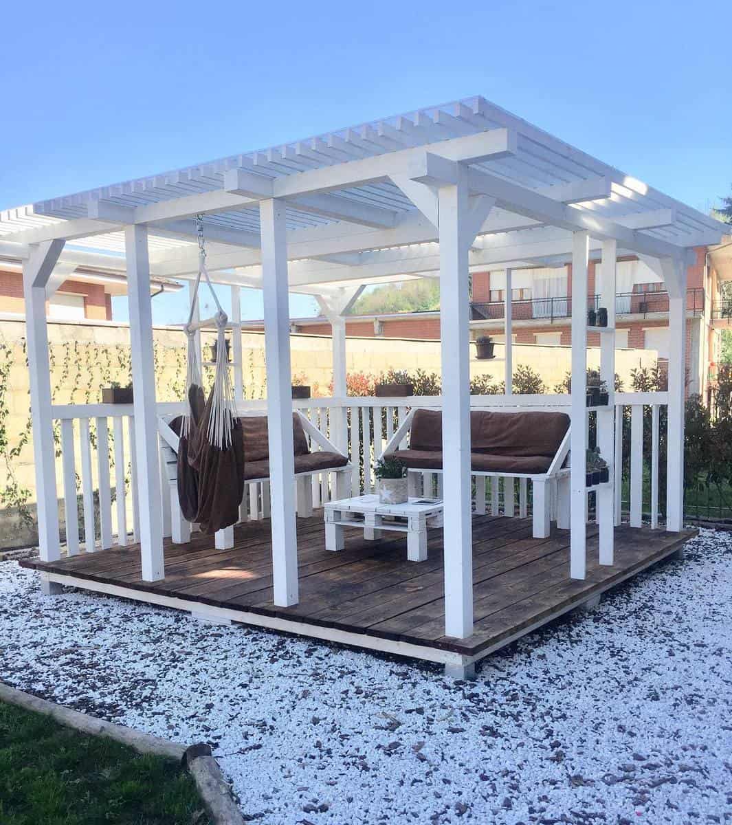 Wooden deck, white pergola in the backyard 