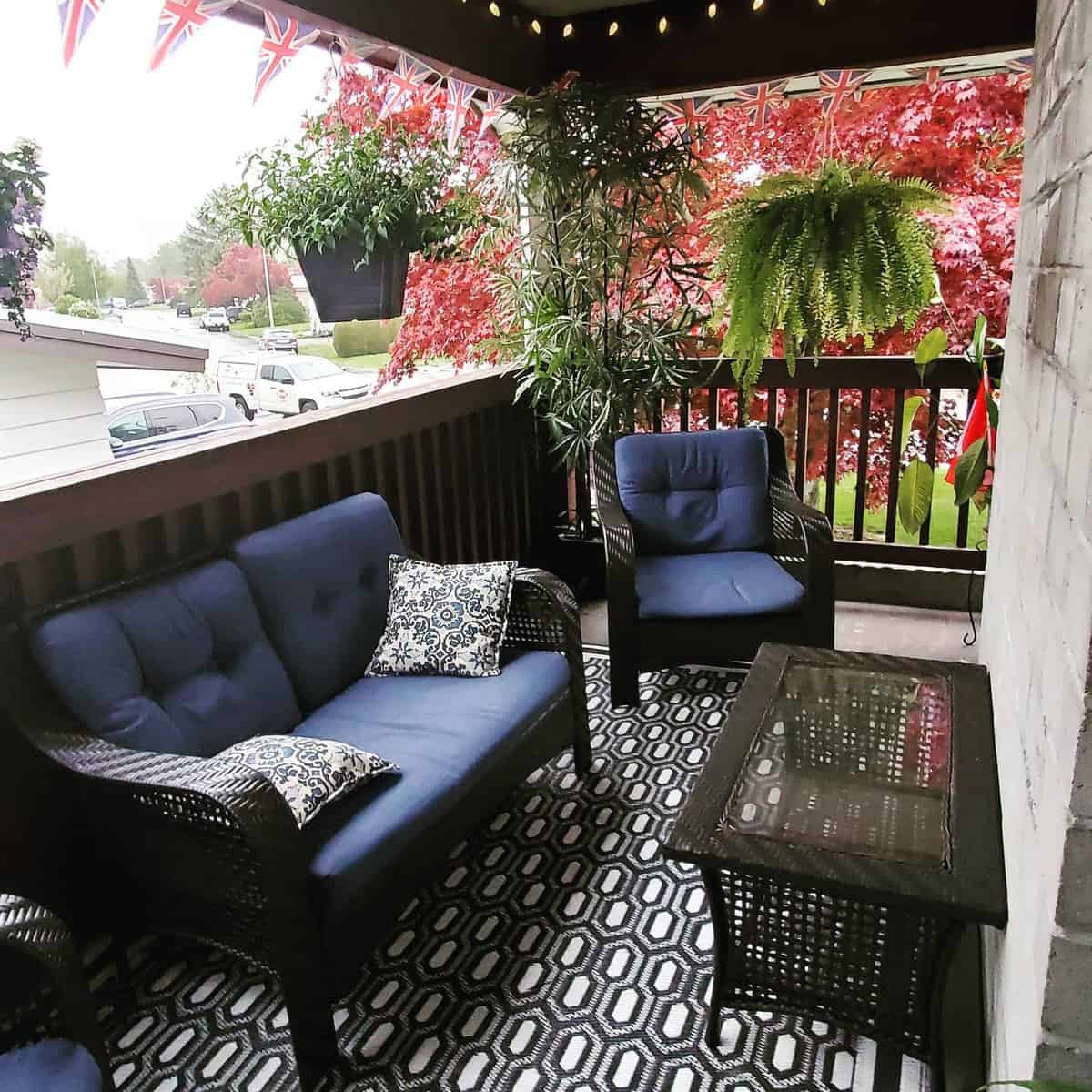 Small slate deck with patterned carpet and outdoor furniture 