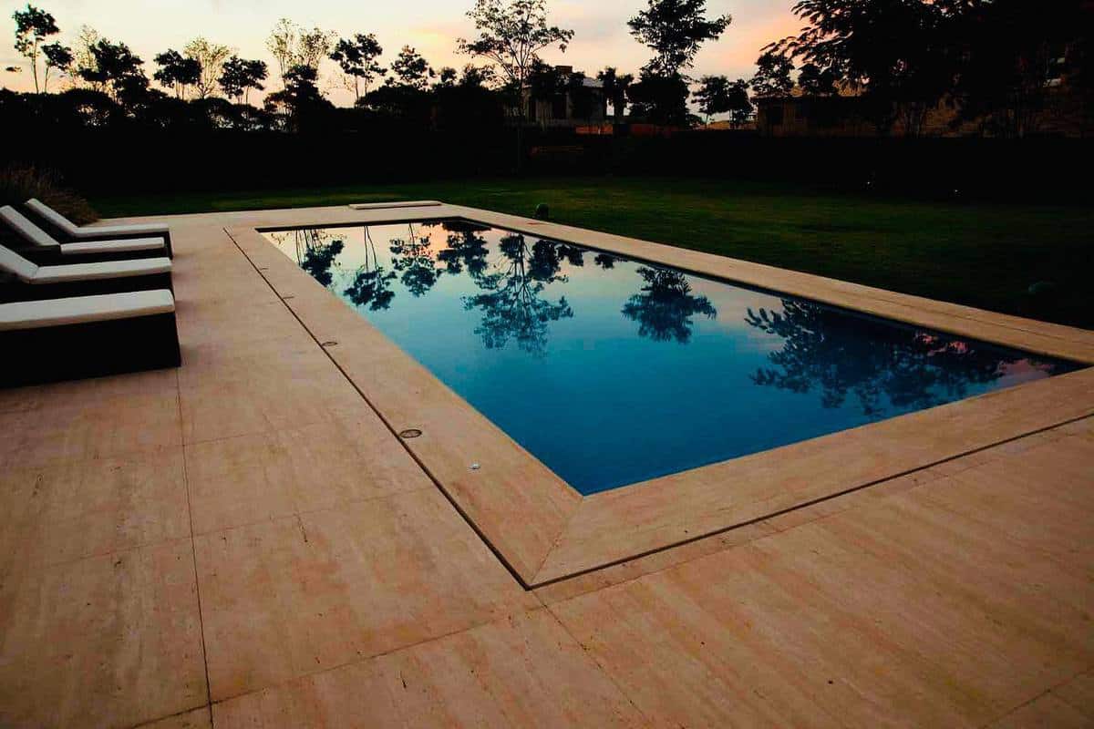 In-ground swimming pool with tan deck