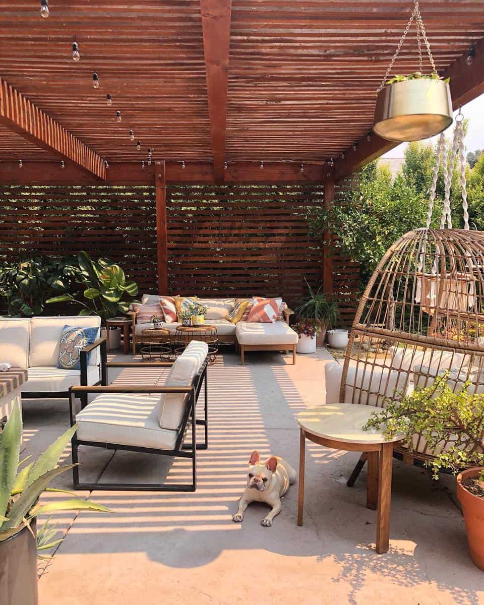 Cement deck, wooden pergola, hanging seat, dog