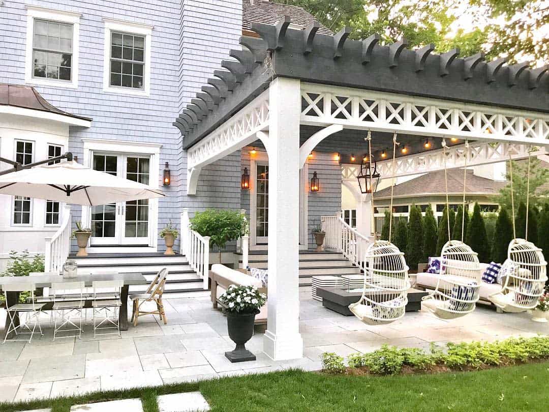 Large, rustic patio with paving stones, garden furniture, hanging egg seats 