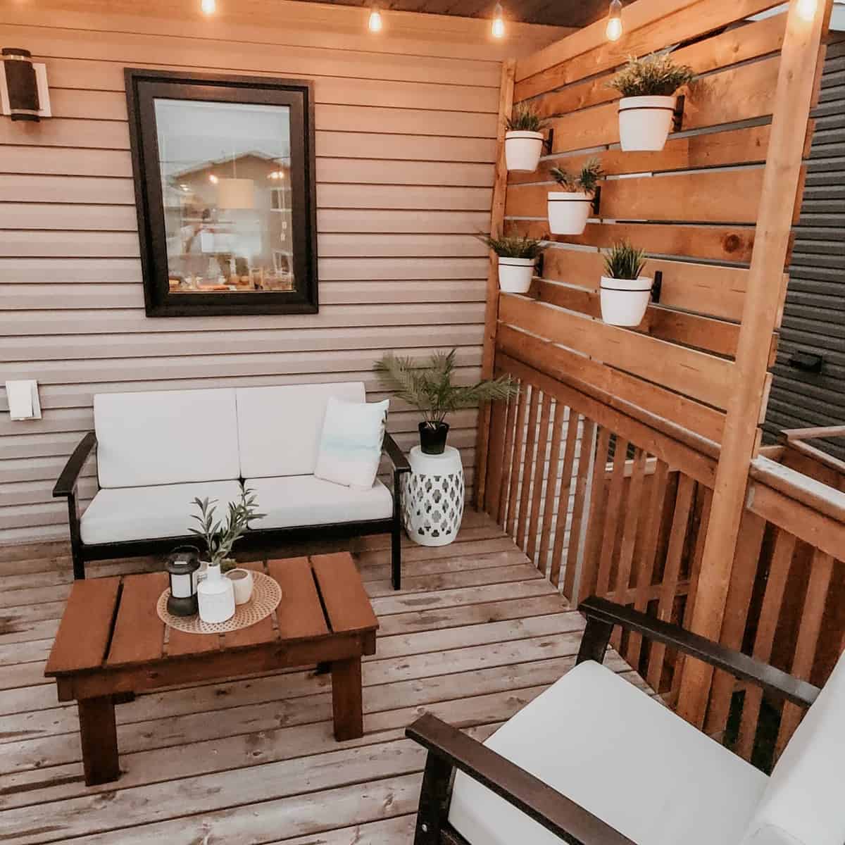 Wooden deck, vertical potted plants, small sofa