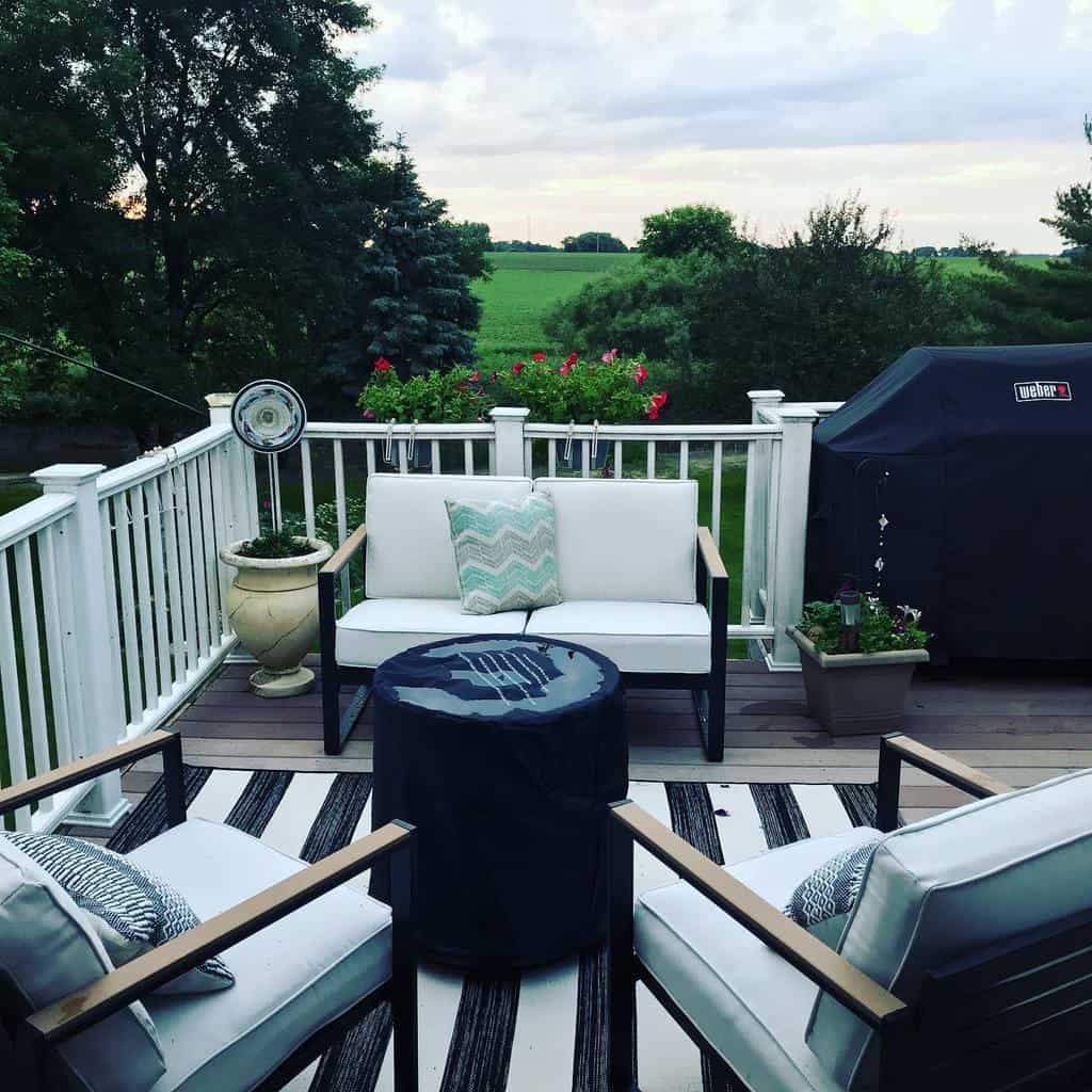 Country deck with white railings and covered grill