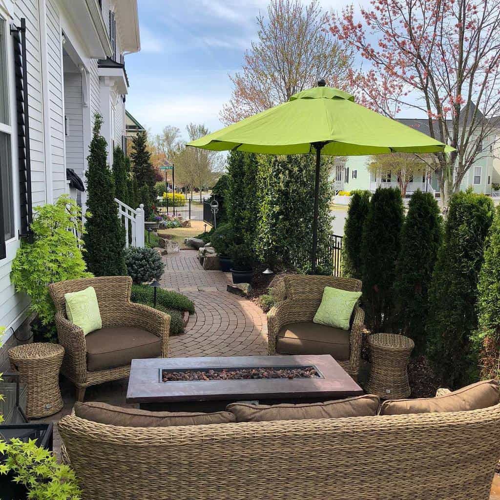 Front yard, patio, wicker furniture, green umbrella, fire pit