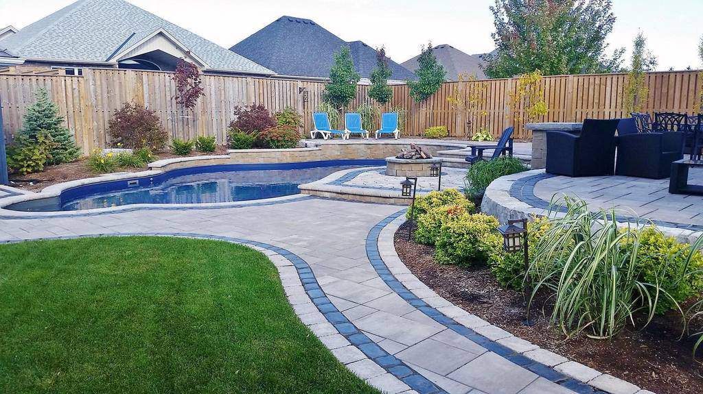 Large backyard with stone paver patio and pool 