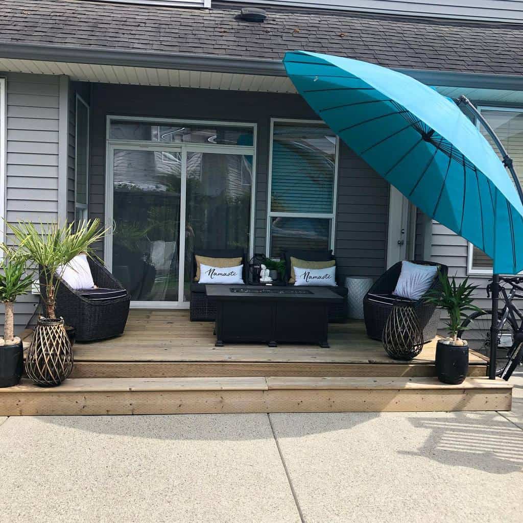 small wooden deck, blue umbrella, black wicker furniture 