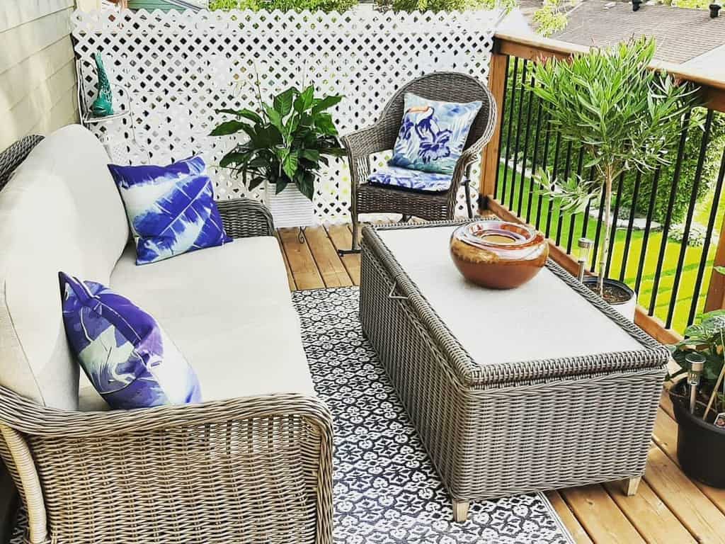 Small wooden deck rug with wicker furniture and plants