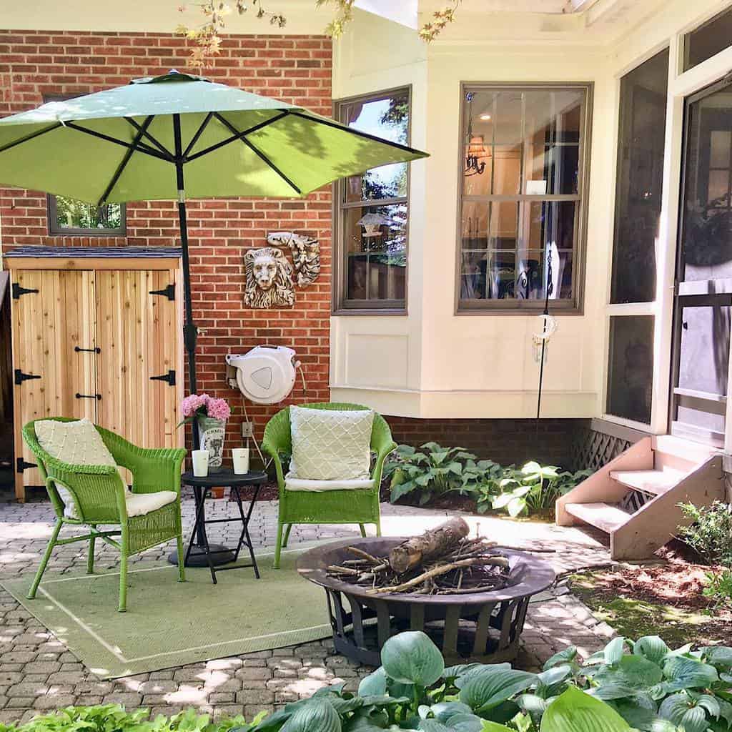 Fire pit with green wicker furniture on backyard patio 