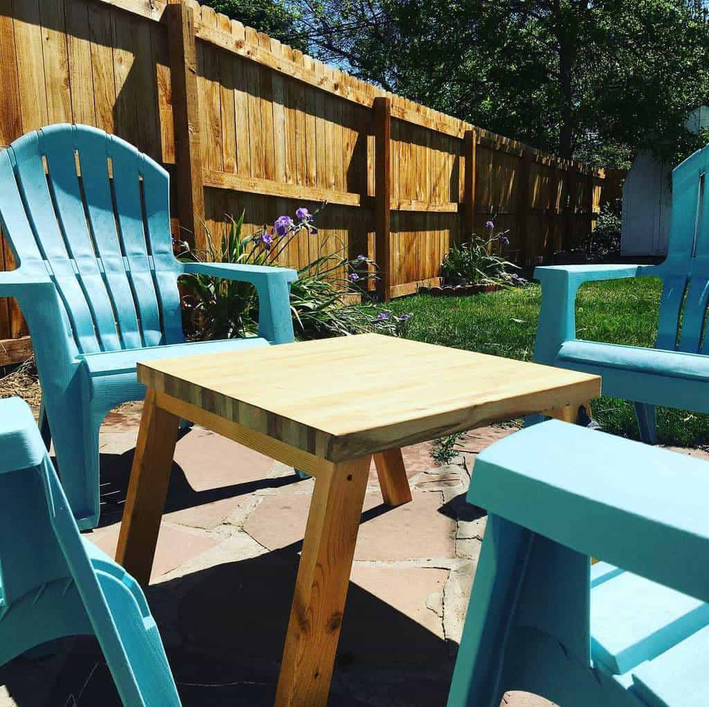 Small terrace with blue plastic chairs and wooden table
