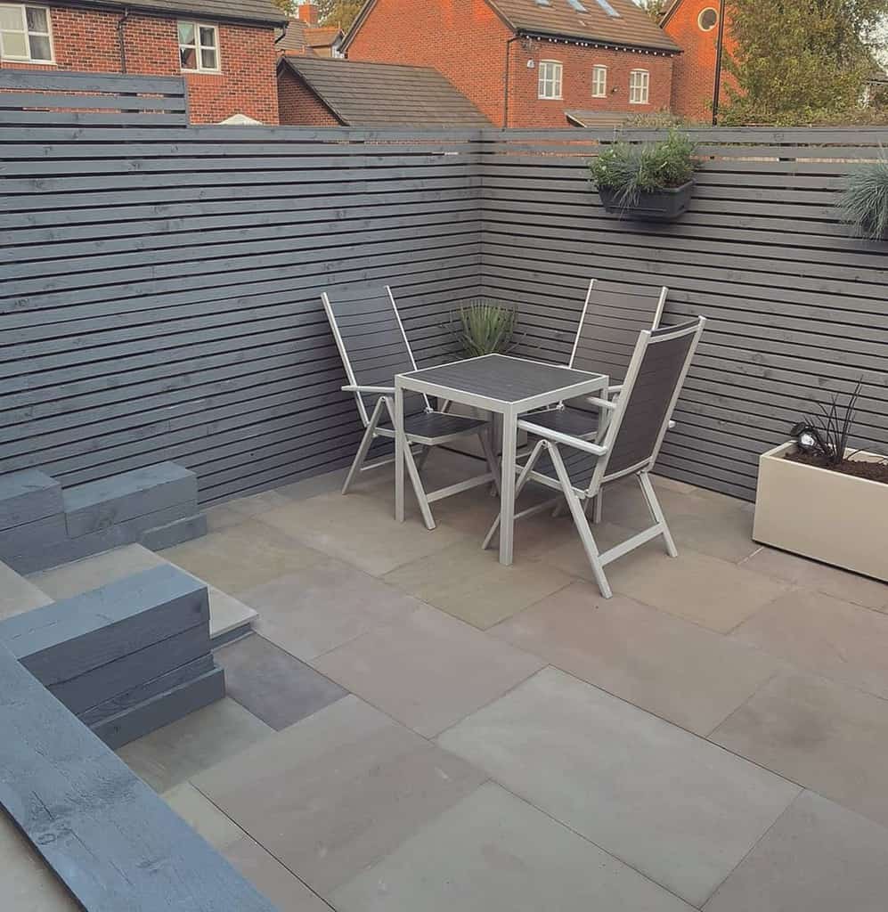 Small terrace made of concrete paving stones with table and chairs 