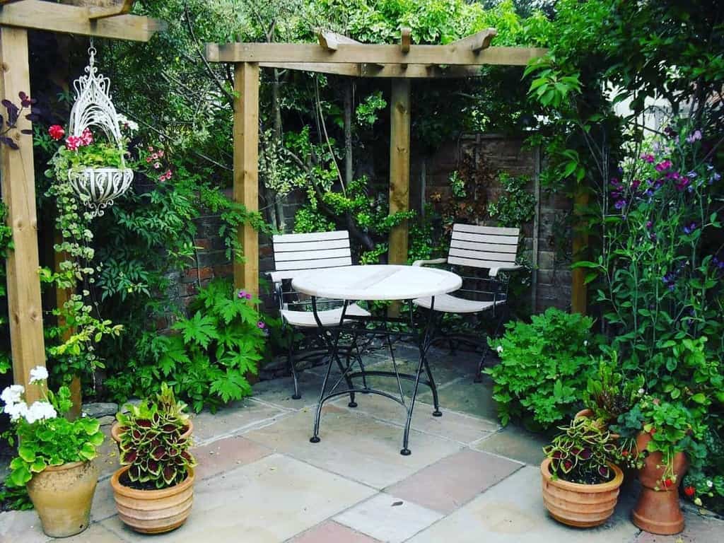 small corner garden terrace with table and chairs 