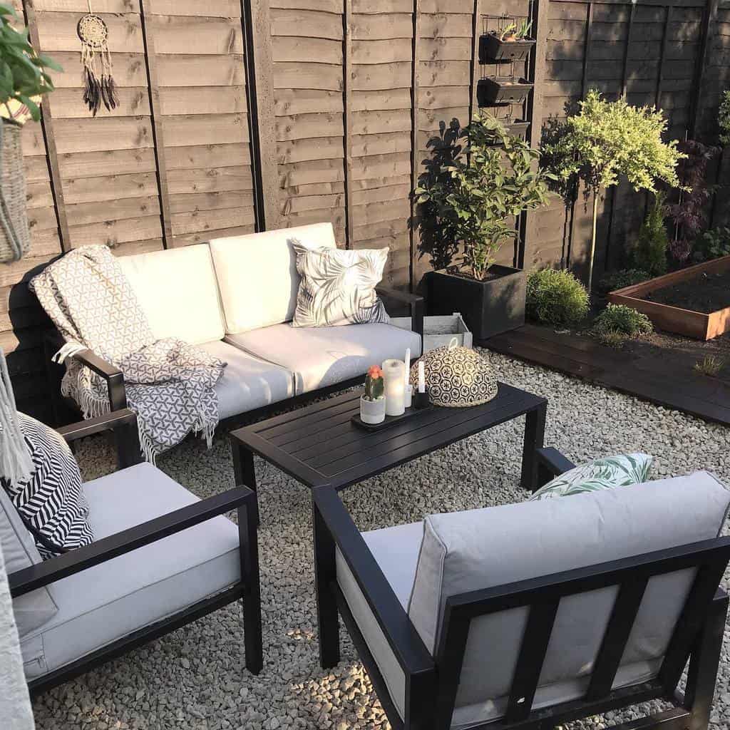 Small corner garden terrace with black garden furniture 