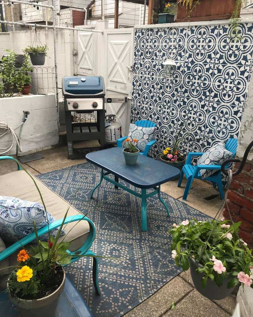 Accent wall with patterned tiles in a small backyard patio with a grill