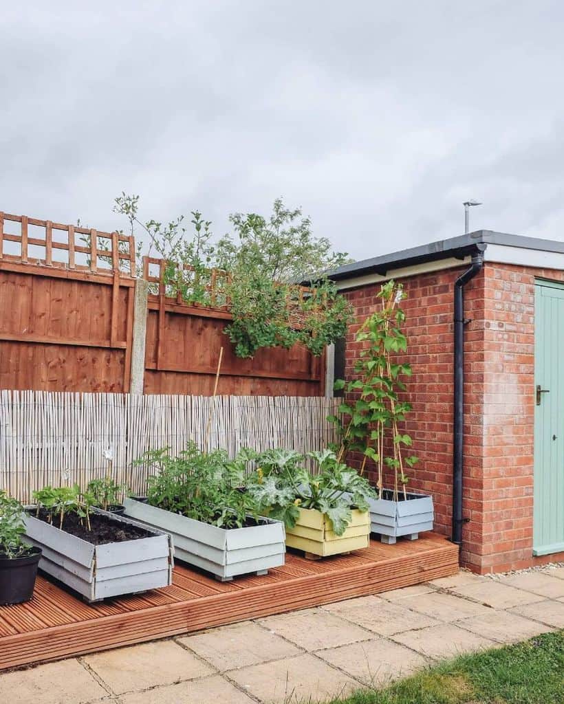 small plant boxes on wooden deck 