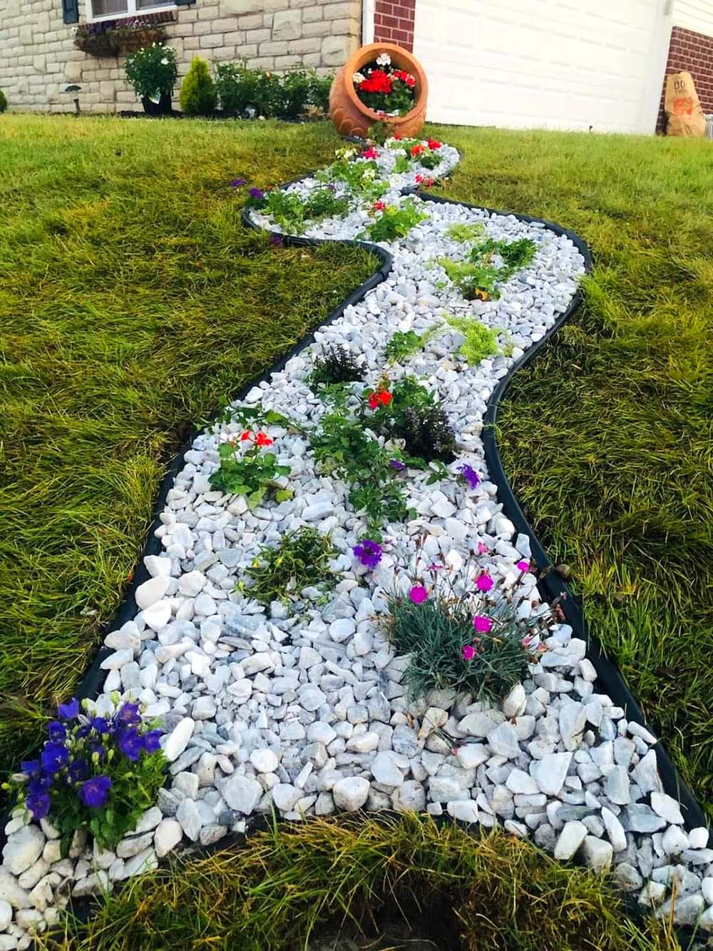 spilled terracotta pot with white stones and small flowers