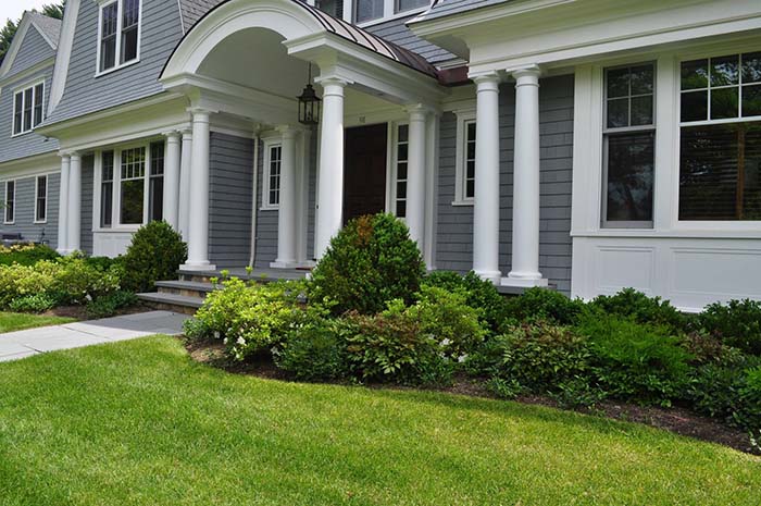 Traditional partly sunny landscaping around the house